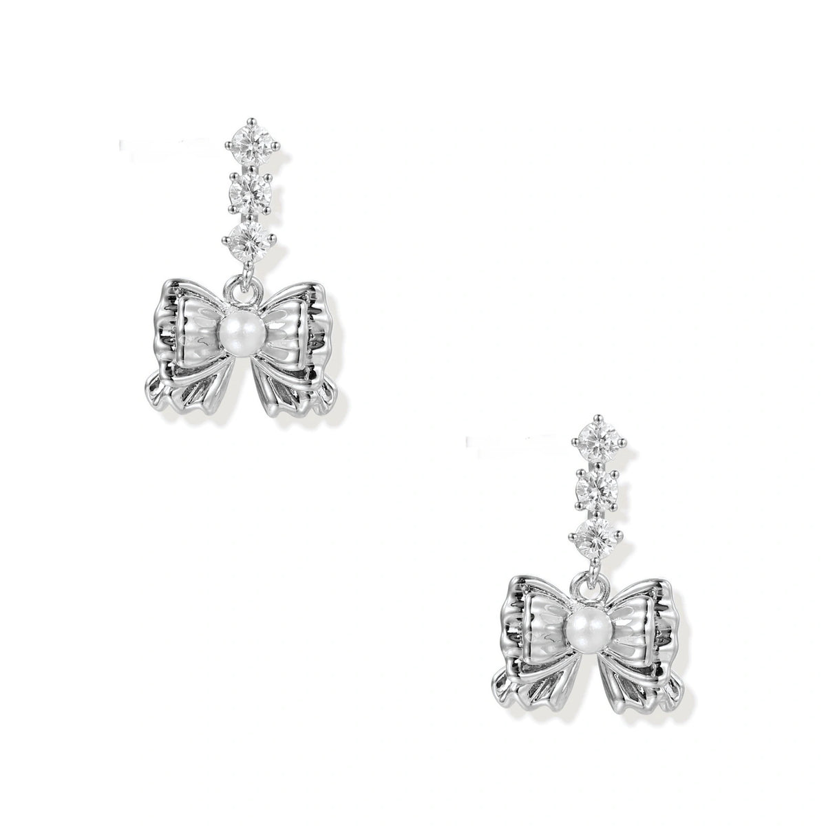 White gold plated drop earrings with three graduated zirconia crystals leading to a bow charm with pearl center