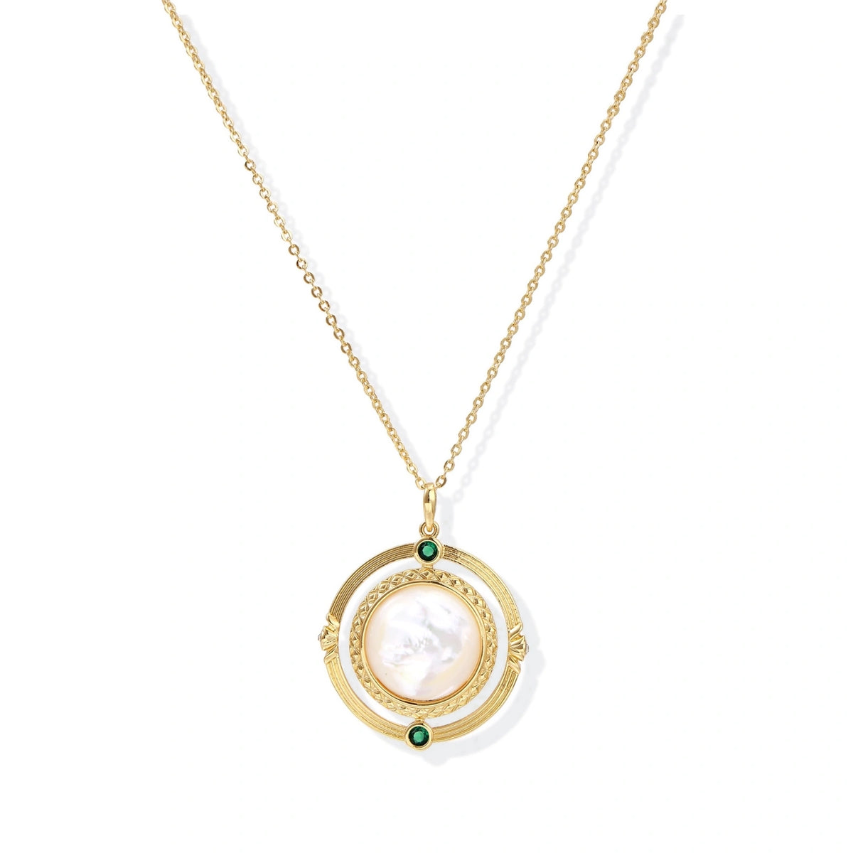 Gold pendant necklace with circular orbital design, iridescent mother-of-pearl center, and green zirconia accents