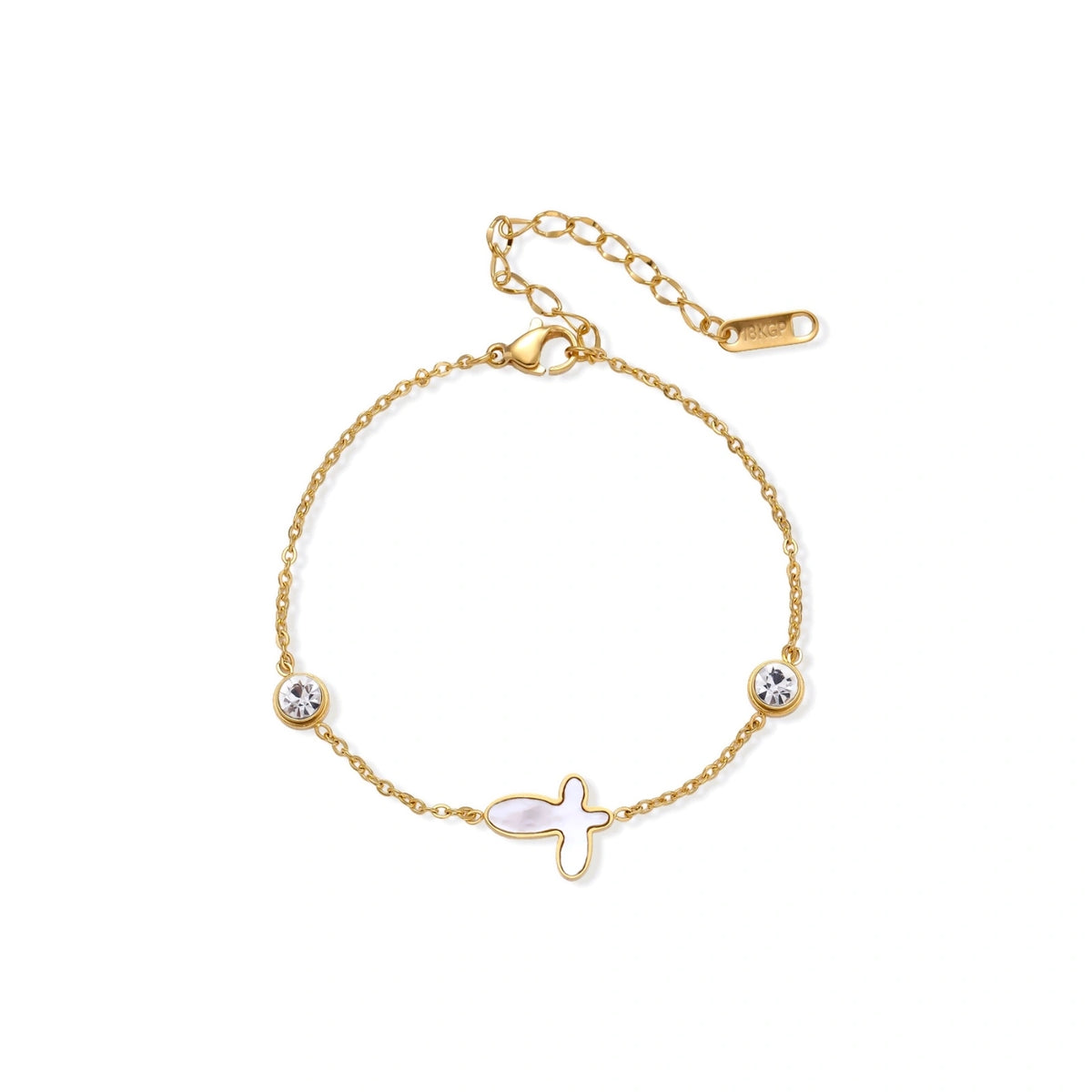 Gold chain bracelet with white mother of pearl butterfly pendant and two bezel-set crystals on cream background