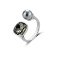 Modern adjustable ring with smoky zircon stone and metallic sphere in platinum-plated copper finish on neutral background.