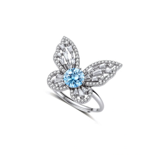 Sterling silver ring with blue moissanite center stone surrounded by clear stones in butterfly wing pattern on white background