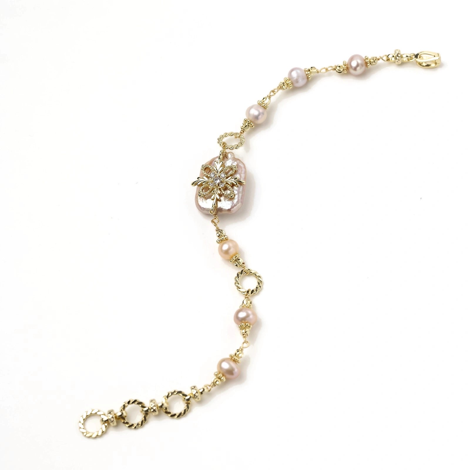 Gold-plated bracelet with pink baroque pearl centerpiece, floral connector, and freshwater pearls
