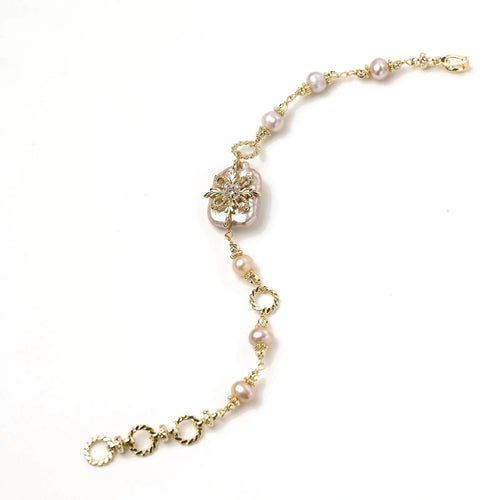 Gold-plated bracelet with pink baroque pearl centerpiece, floral connector, and freshwater pearls