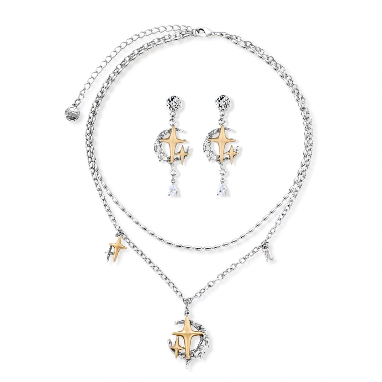 Delicate eco-brass jewelry set featuring gold star and silver moon crescents with clear zirconia crystal drops on cream background