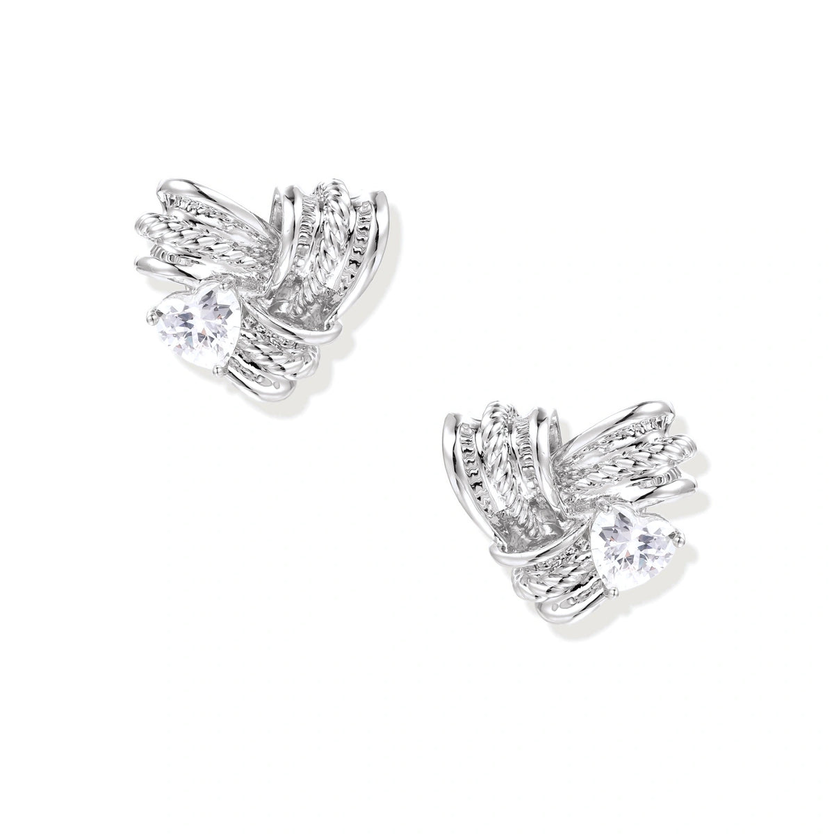 Pair of sculptural white gold-plated stud earrings with twisted ribbon design and sparkling zirconia stones on cream background