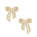 Gold-plated bow earrings with openwork design, marquise center stones, and flowing ribbon tails adorned with zirconia crystals.