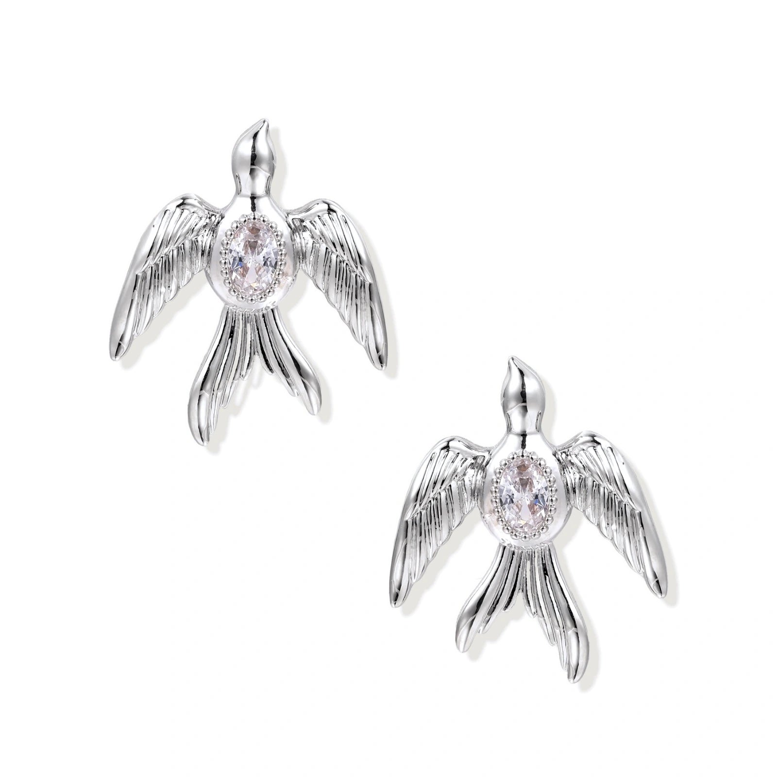 White gold-plated bird earrings with spread wings and oval zirconia center on cream background