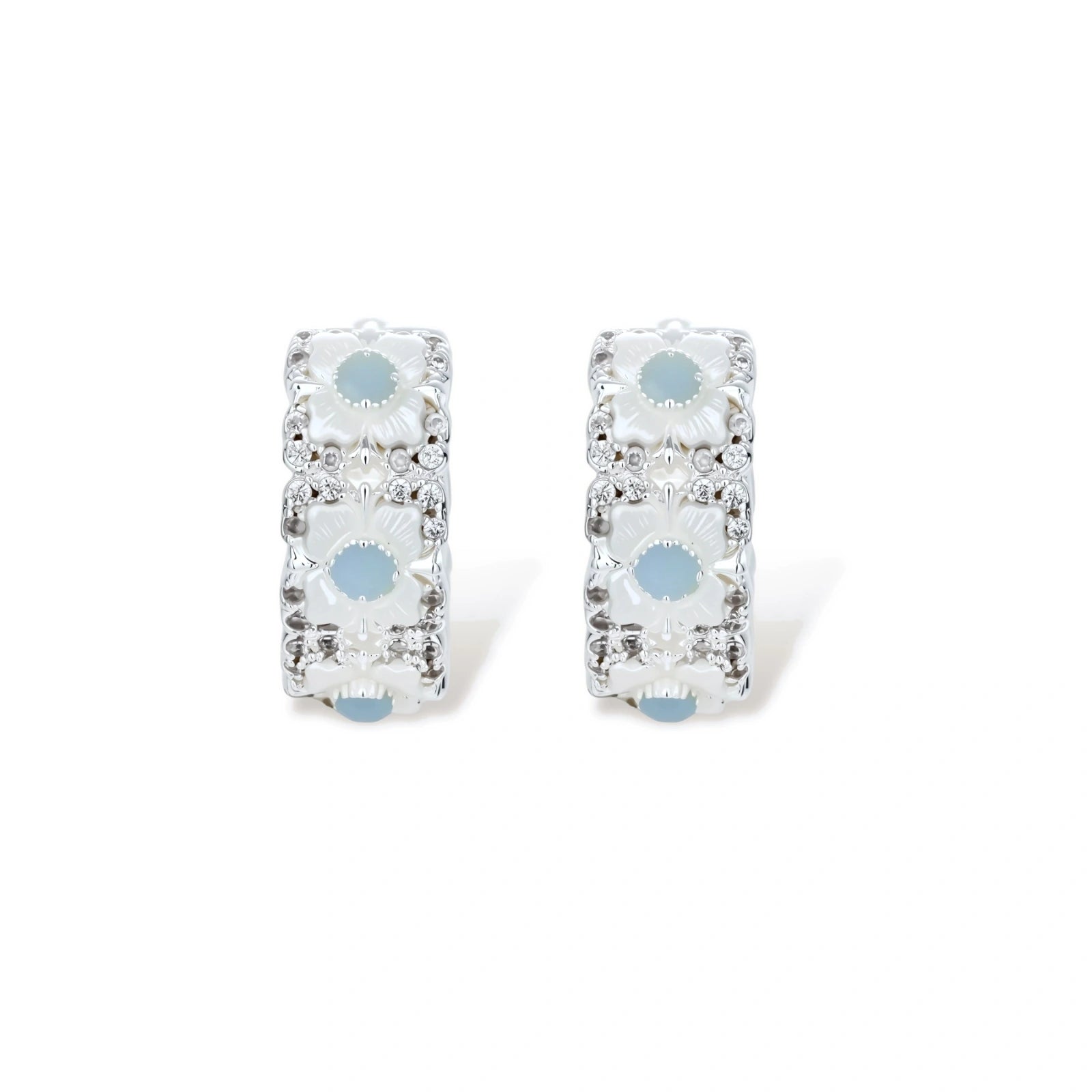 Silver-plated hoop earrings featuring delicate daisy flowers with powder blue centers and crystal accents on white background.