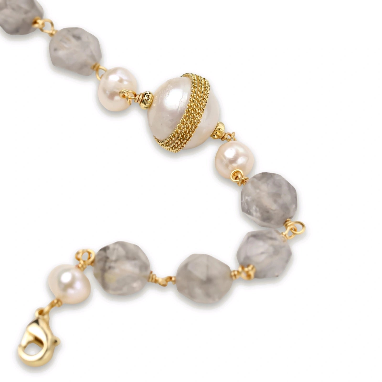 Bracelet with cloudy quartz beads, freshwater pearls, and gold-wrapped baroque pearl centerpiece on white background.