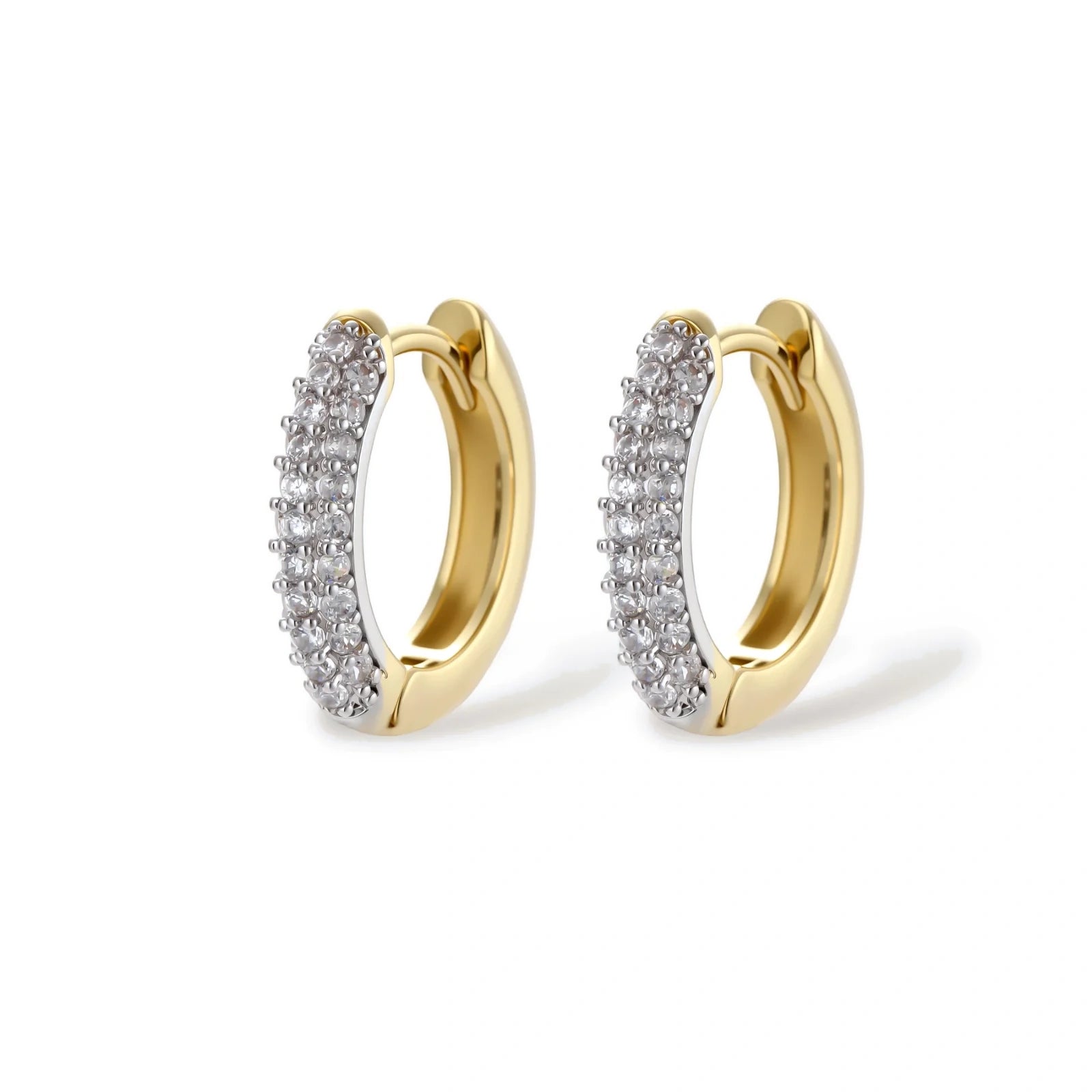 Gold-plated curved necklace, hoop earrings, and adjustable ring with pavé cubic zirconia stones on cream background.