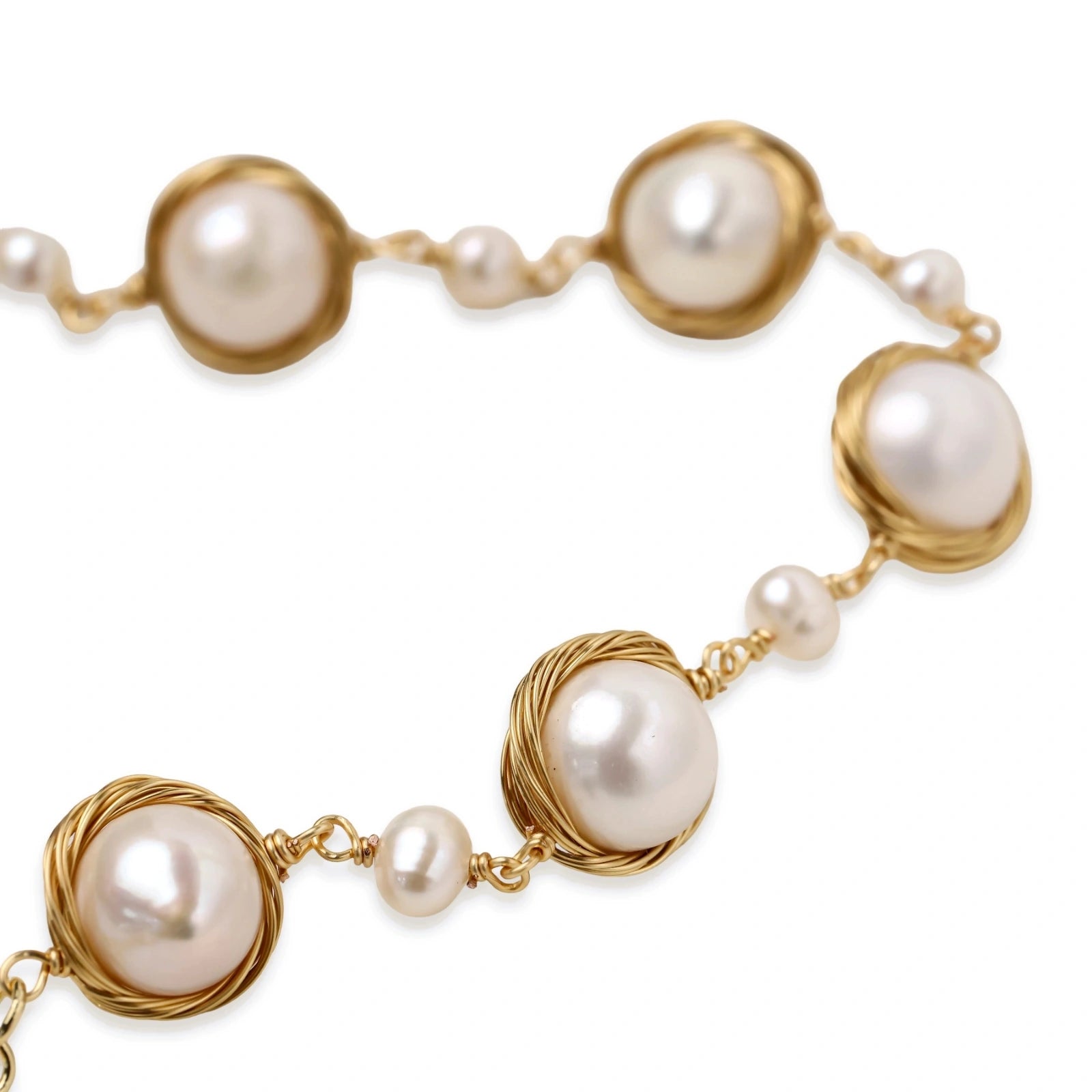 Gold wire-wrapped freshwater pearl bracelet with alternating pearl sizes on cream background, adjustable length