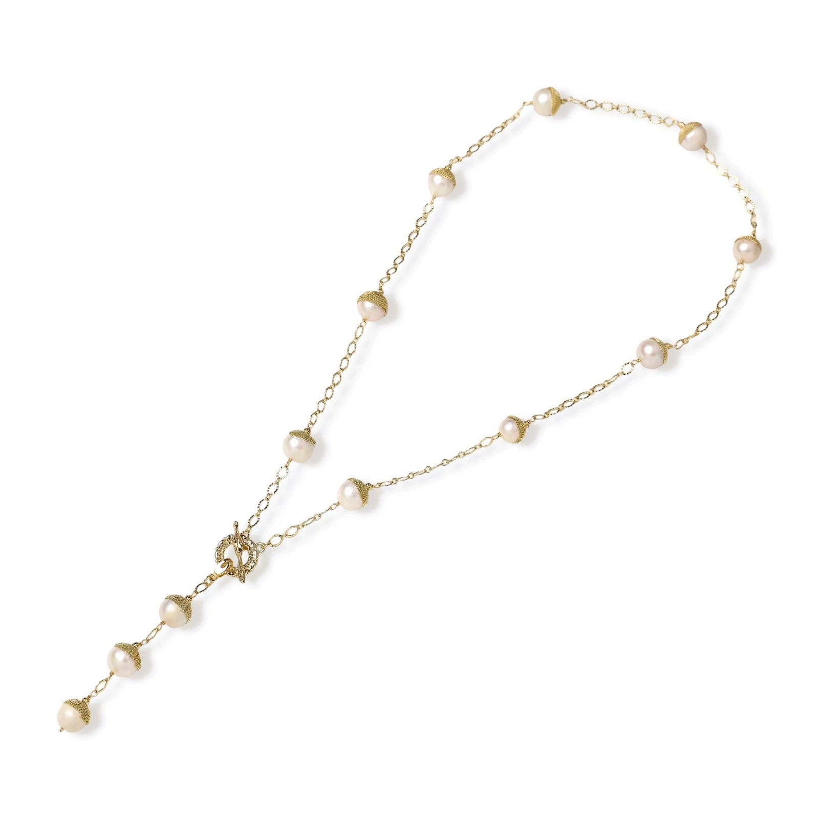 Gold-plated lariat necklace with baroque pearls and textured caps on cream background, showing adjustable Y-shaped design.