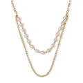 Layered gold chain necklace with organic baroque freshwater pearls and adjustable length on cream background
