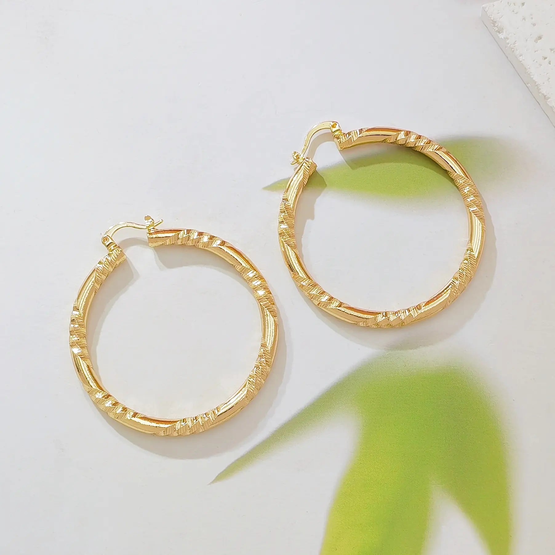 Twisted Gold Huggie Hoops — faceted diamond-cut huggie hoop earrings