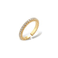 Close-up of adjustable gold-plated ring with continuous row of round zirconia stones on neutral background.