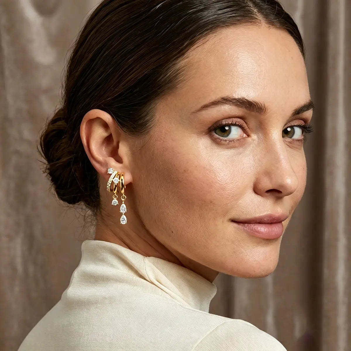 Triple Stack Huggie Earrings — three-tier huggie hoops with cubic zirconia drops