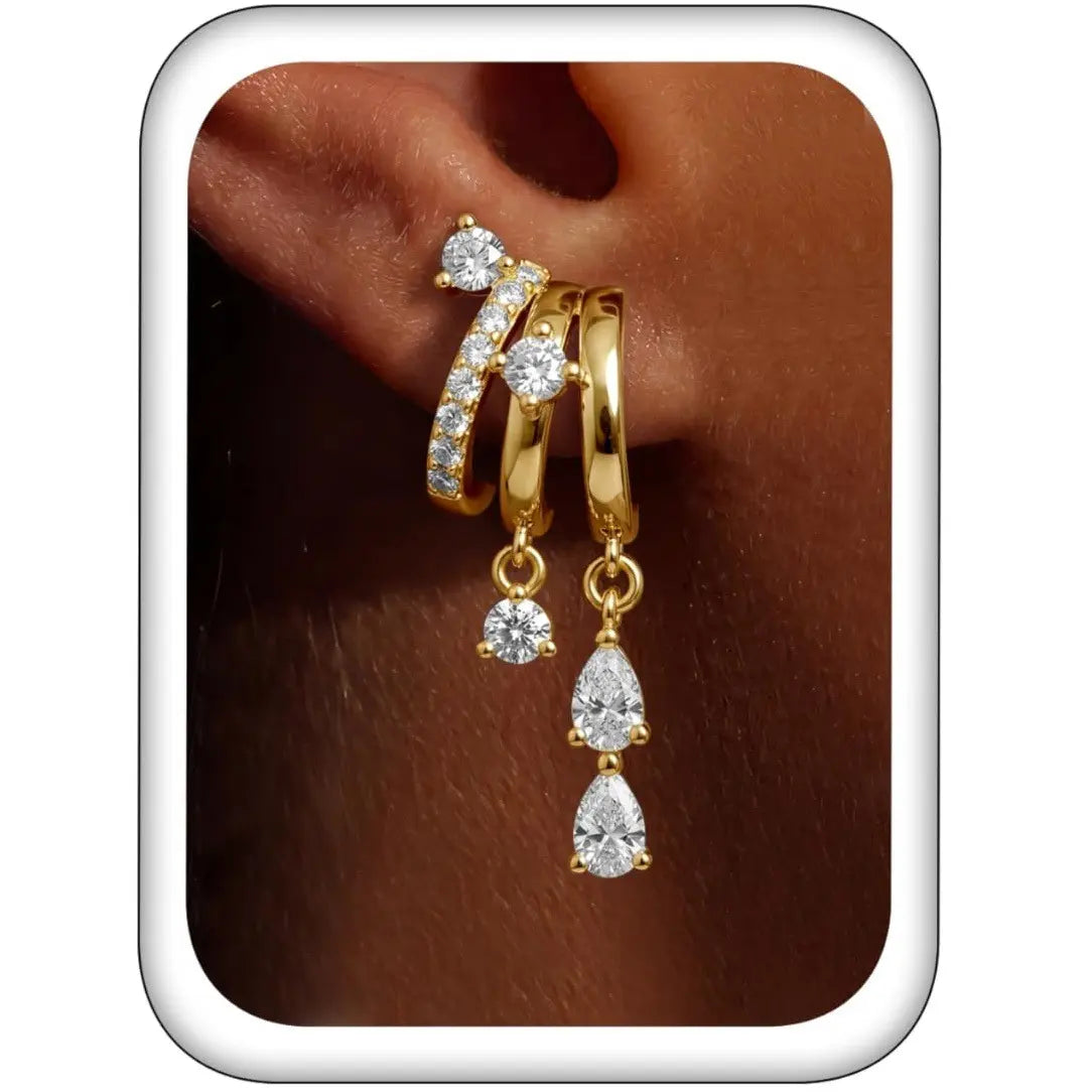 Triple Stack Huggie Earrings — three-tier huggie hoops with cubic zirconia drops