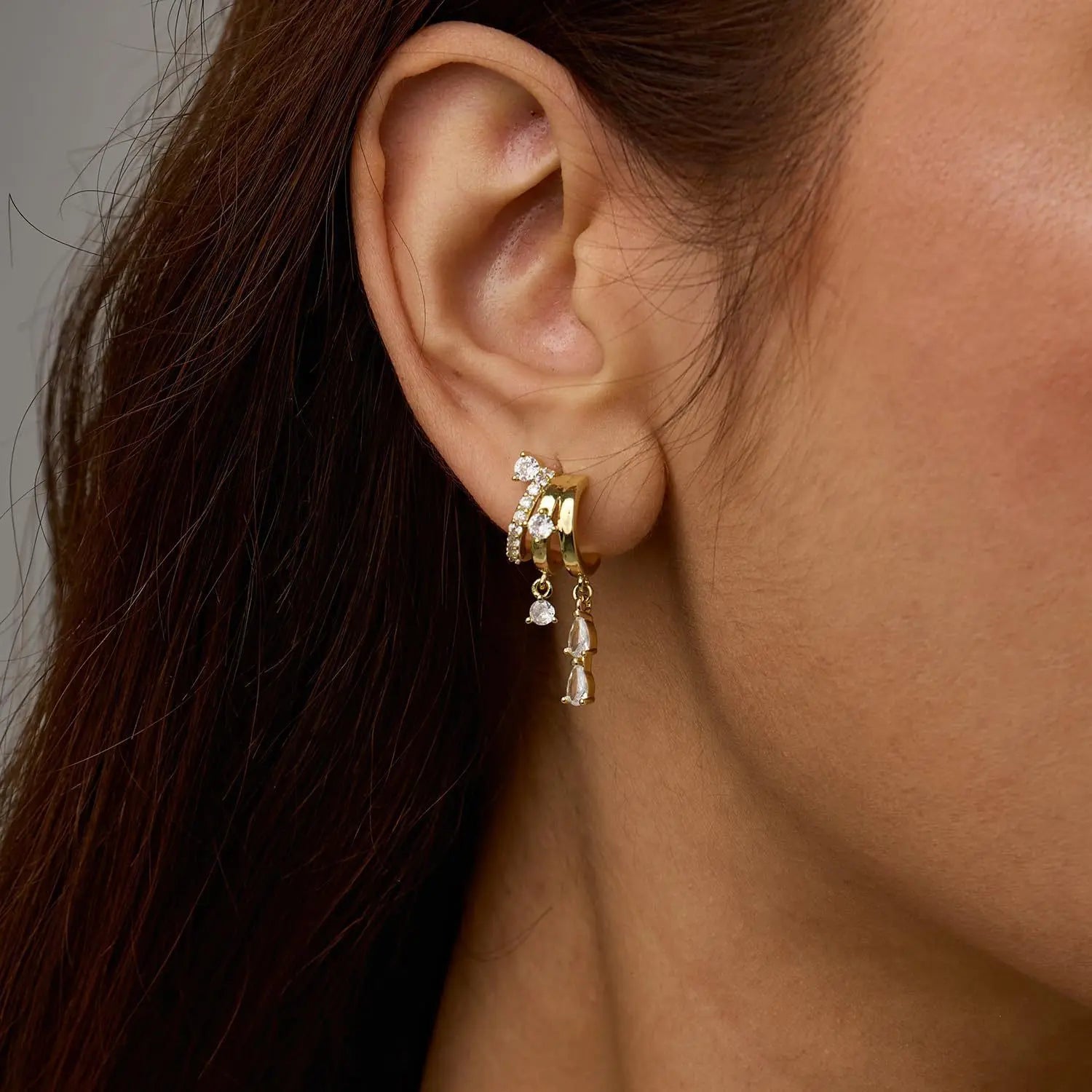 Triple Stack Huggie Earrings — three-tier huggie hoops with cubic zirconia drops