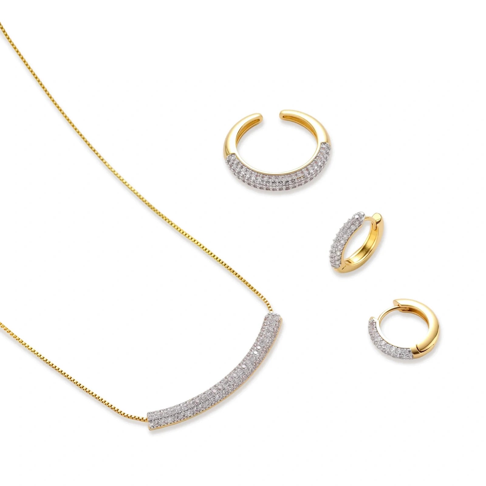 Gold-plated curved necklace, hoop earrings, and adjustable ring with pavé cubic zirconia stones on cream background.