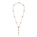 Gold-plated lariat necklace with baroque pearls and textured caps on cream background, showing adjustable Y-shaped design.